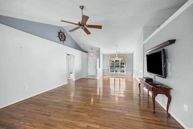 living room with a textured ceiling, dark hardwood / wood-style flooring, high vaulted ceiling, and ceiling fan