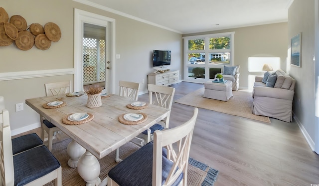 dining space with light wood-type flooring and crown molding