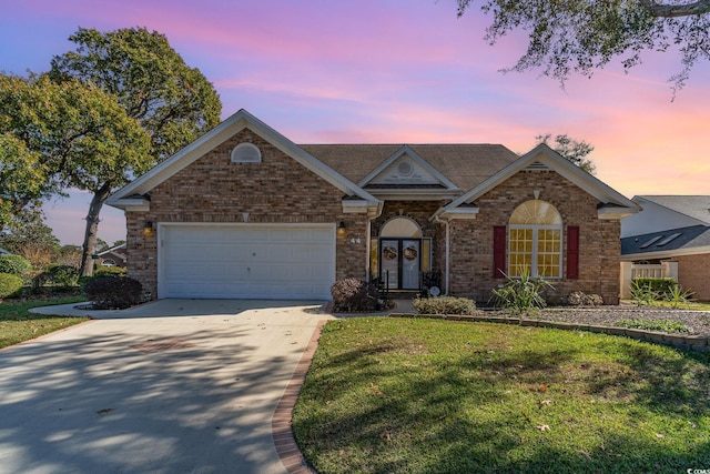 ranch-style home featuring a garage and a lawn