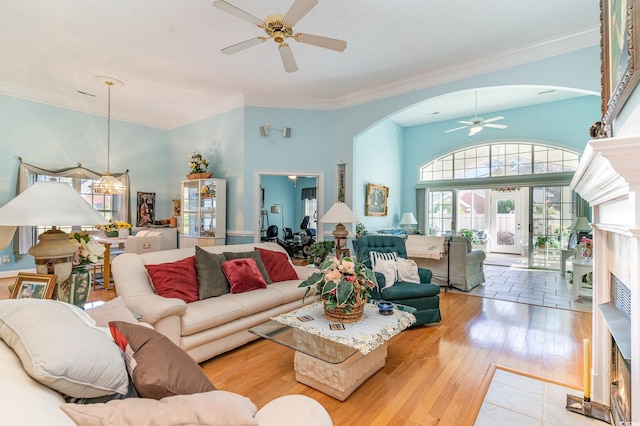 living room featuring ceiling fan, light hardwood / wood-style floors, ornamental molding, and french doors