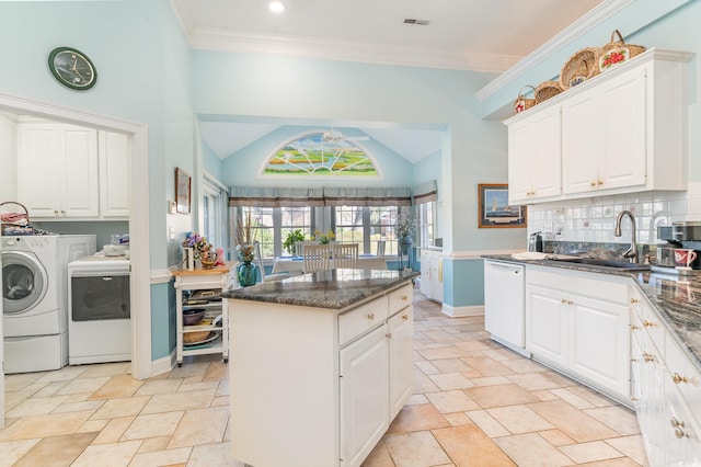 kitchen with white cabinets, dishwasher, a kitchen island, and washer and dryer