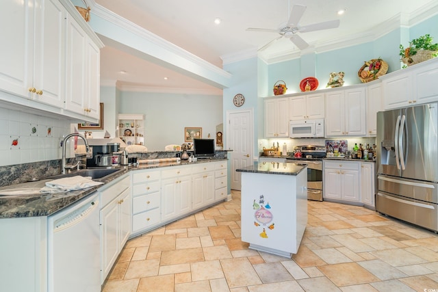 kitchen with stainless steel appliances, crown molding, sink, a center island, and white cabinetry