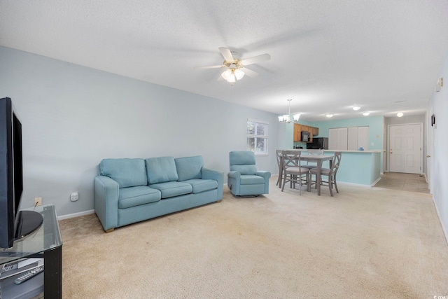 carpeted living room featuring ceiling fan with notable chandelier and a textured ceiling