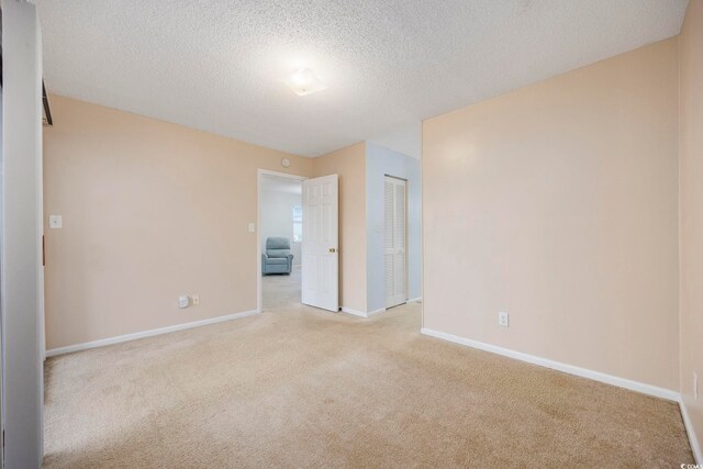 carpeted empty room with a textured ceiling