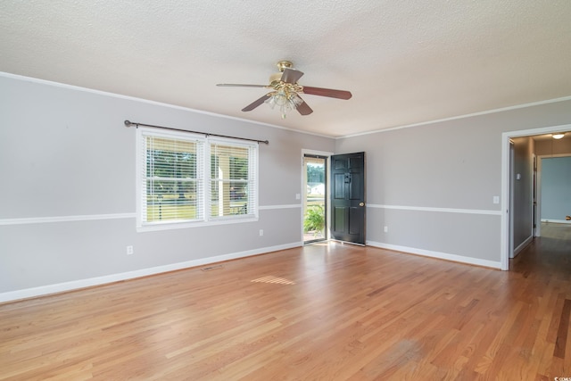 unfurnished room featuring a textured ceiling, ceiling fan, light wood-type flooring, and crown molding