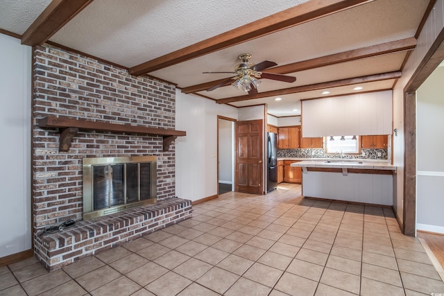 kitchen with kitchen peninsula, decorative backsplash, refrigerator, light tile patterned floors, and a breakfast bar area