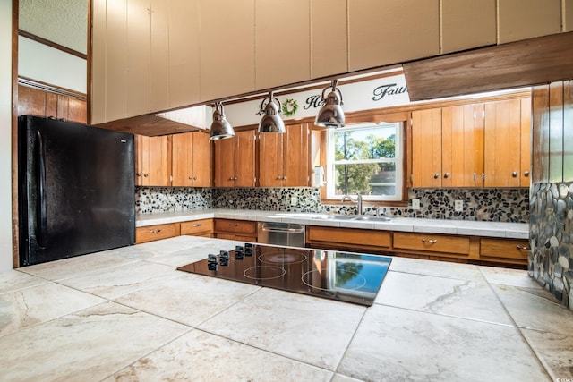 kitchen featuring black refrigerator, tile countertops, stainless steel dishwasher, and sink