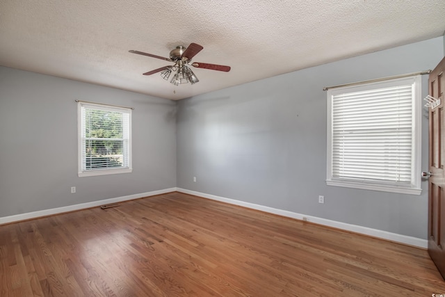 unfurnished room with hardwood / wood-style floors, ceiling fan, and a textured ceiling