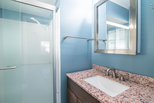 bathroom featuring vanity and a shower with shower door