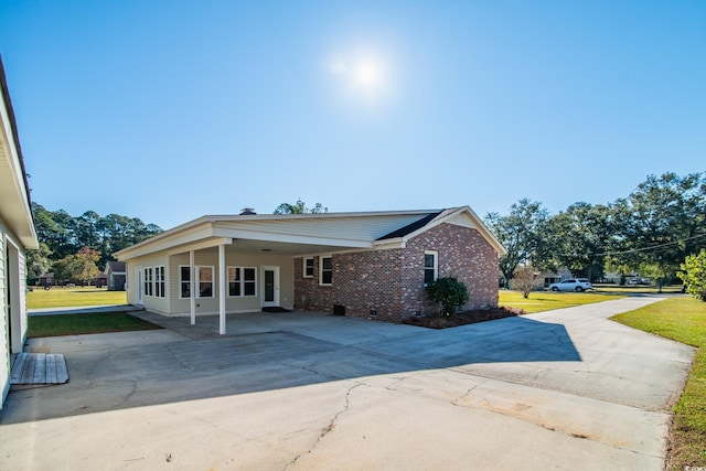 exterior space featuring a carport and a lawn