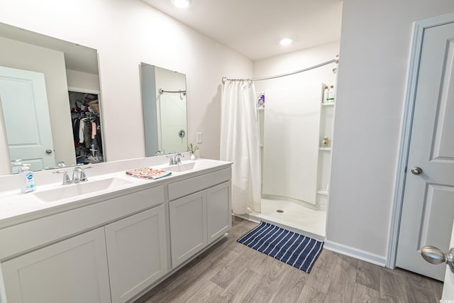 bathroom featuring hardwood / wood-style floors, vanity, and walk in shower