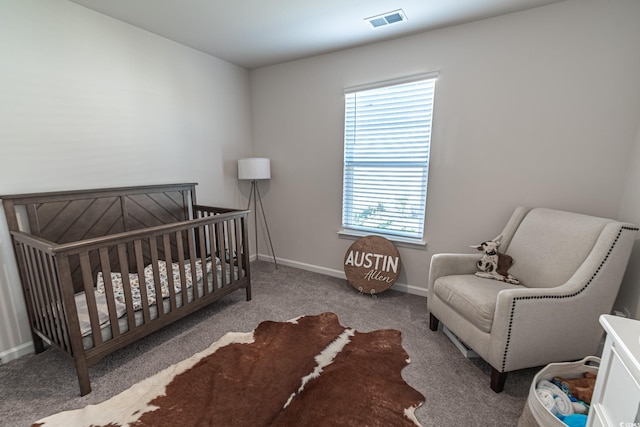 carpeted bedroom featuring a crib