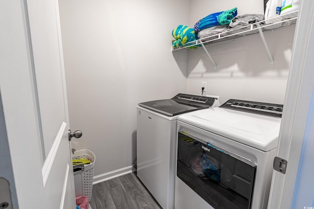 clothes washing area featuring washer and dryer and dark hardwood / wood-style flooring