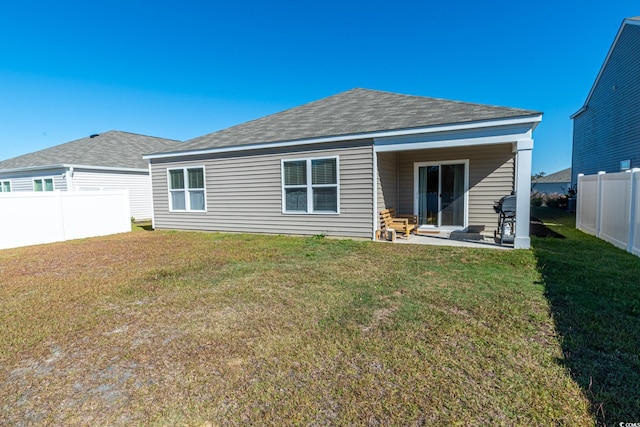 back of property with a lawn and a patio