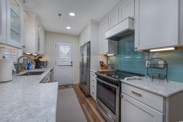 kitchen with dark hardwood / wood-style flooring, custom exhaust hood, stainless steel appliances, sink, and white cabinets