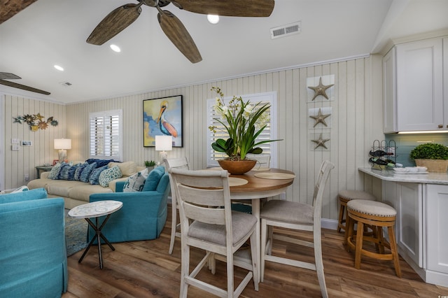 dining space featuring wood walls and dark hardwood / wood-style flooring