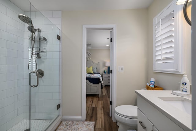 bathroom featuring walk in shower, ornamental molding, vanity, wood-type flooring, and toilet