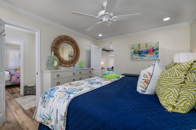 bedroom featuring ceiling fan, ornamental molding, and light hardwood / wood-style flooring