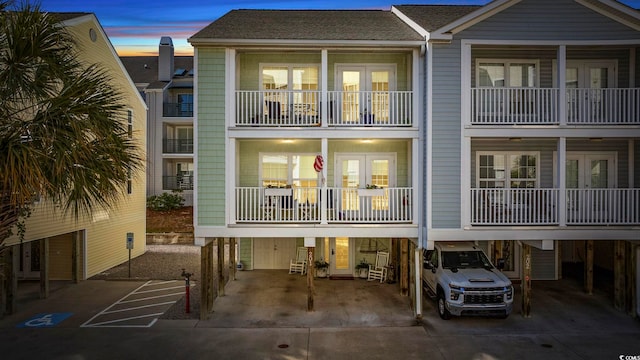 209 N Hillside Dr Unit 201, North Myrtle Beach, SC 29582 - back of property at dusk with a carport and concrete driveway