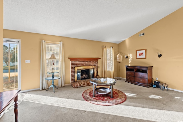 carpeted living room featuring a brick fireplace, a textured ceiling, and vaulted ceiling