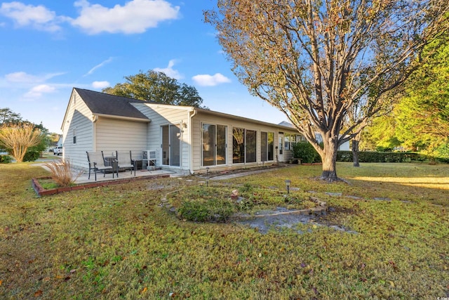 rear view of property with a yard and a patio