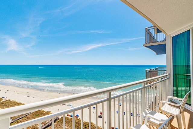 balcony featuring a water view and a beach view