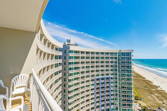 view of building exterior featuring a beach view and a water view