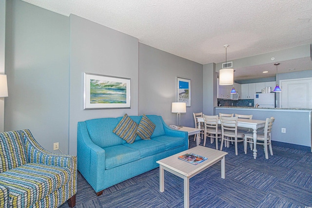 carpeted living room featuring a textured ceiling