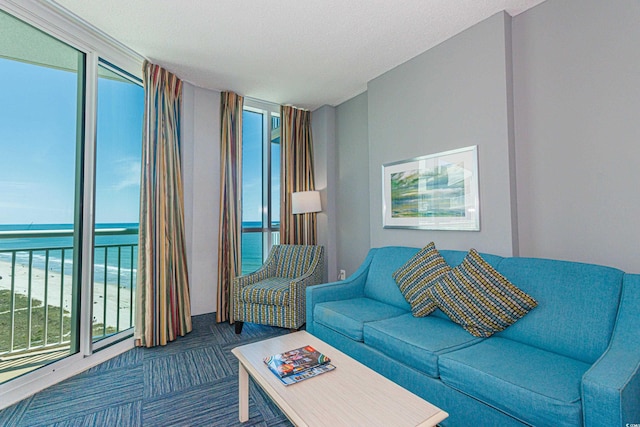 living room with carpet, a water view, and a textured ceiling