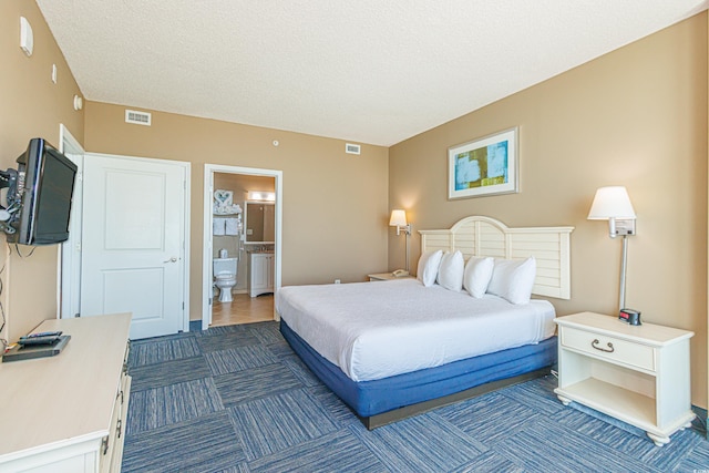 bedroom with a textured ceiling and connected bathroom