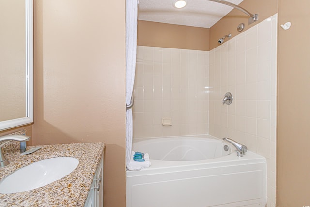 bathroom with vanity, shower / bath combination, and a textured ceiling