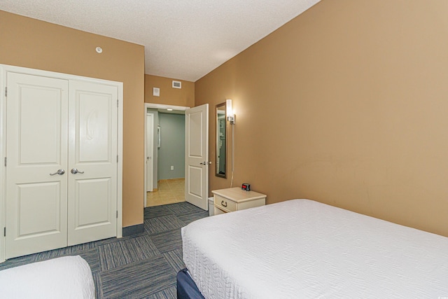 bedroom with a textured ceiling and a closet