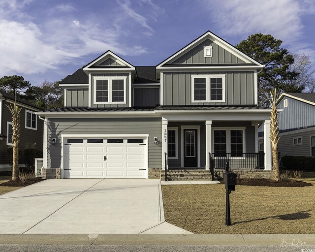 view of front facade with covered porch, a garage, concrete driveway, board and batten siding, and a standing seam roof