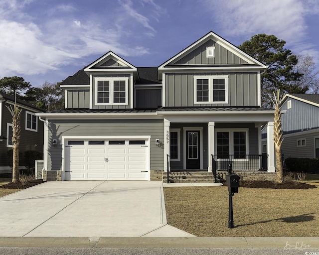 traditional-style home featuring a porch, board and batten siding, an attached garage, and a standing seam roof