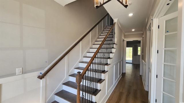 stairway featuring wood-type flooring and ornamental molding