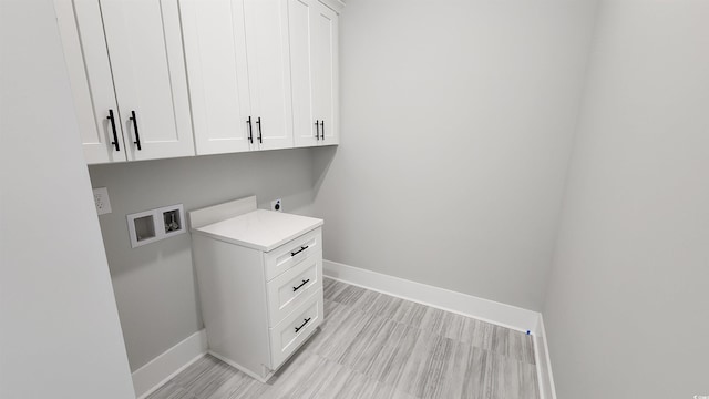 washroom with washer hookup, electric dryer hookup, and cabinets