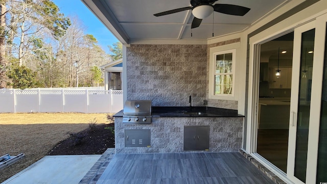 view of patio featuring ceiling fan, sink, and grilling area