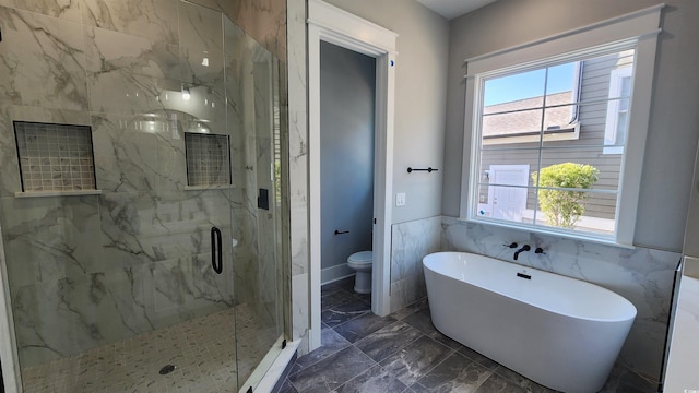 bathroom featuring toilet, tile walls, and separate shower and tub