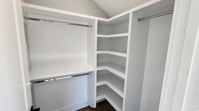 walk in closet with dark hardwood / wood-style floors and lofted ceiling