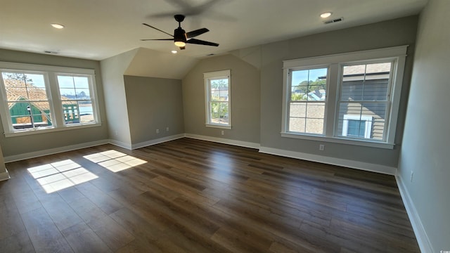 additional living space featuring ceiling fan, a healthy amount of sunlight, vaulted ceiling, and dark hardwood / wood-style floors