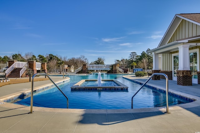 view of pool featuring pool water feature and a hot tub