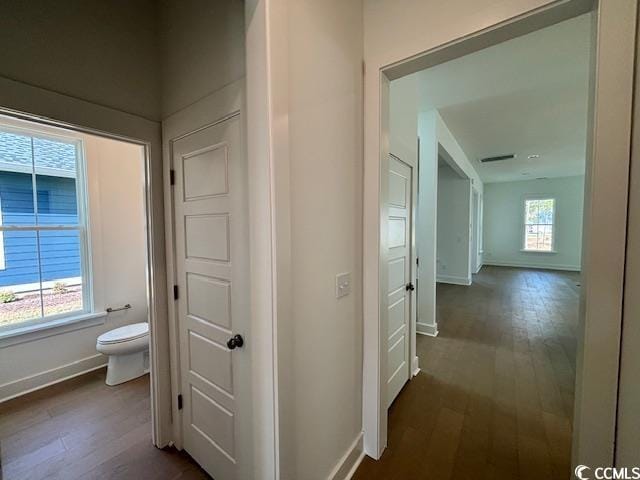 corridor with baseboards and dark wood finished floors