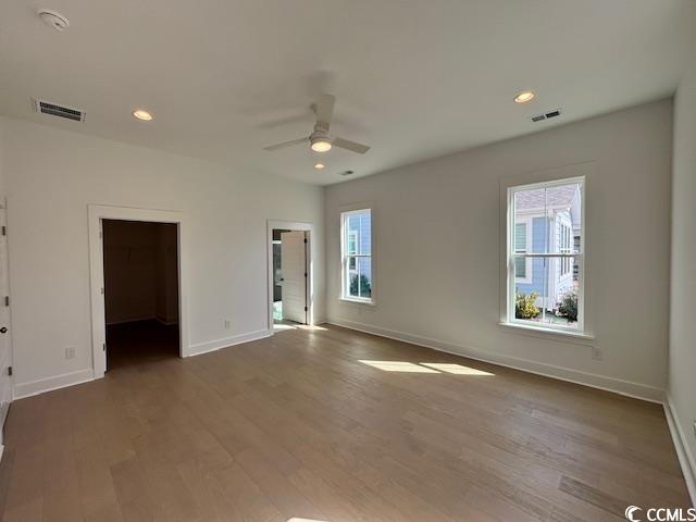 spare room featuring baseboards, a ceiling fan, wood finished floors, and recessed lighting