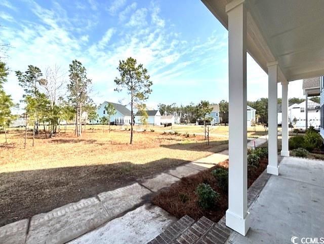 view of yard with covered porch and a residential view