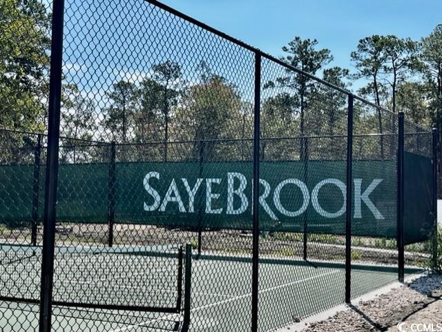 view of tennis court featuring fence
