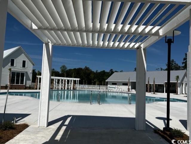 community pool with a pergola and a patio