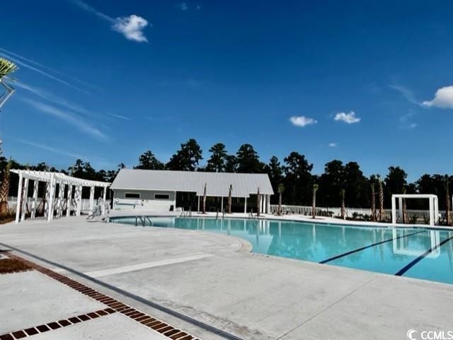 community pool with a pergola and a patio area