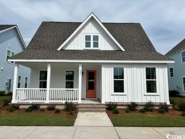 view of front of property featuring covered porch, roof with shingles, and board and batten siding