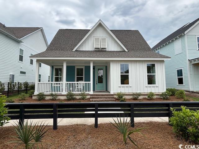 734 Macon Aly, Myrtle Beach, SC 29588 - view of front of house with covered porch, board and batten siding, a fenced front yard, and roof with shingles