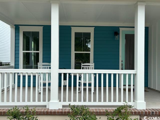 734 Macon Aly, Myrtle Beach, SC 29588 - modern farmhouse with board and batten siding, covered porch, a front yard, and a shingled roof